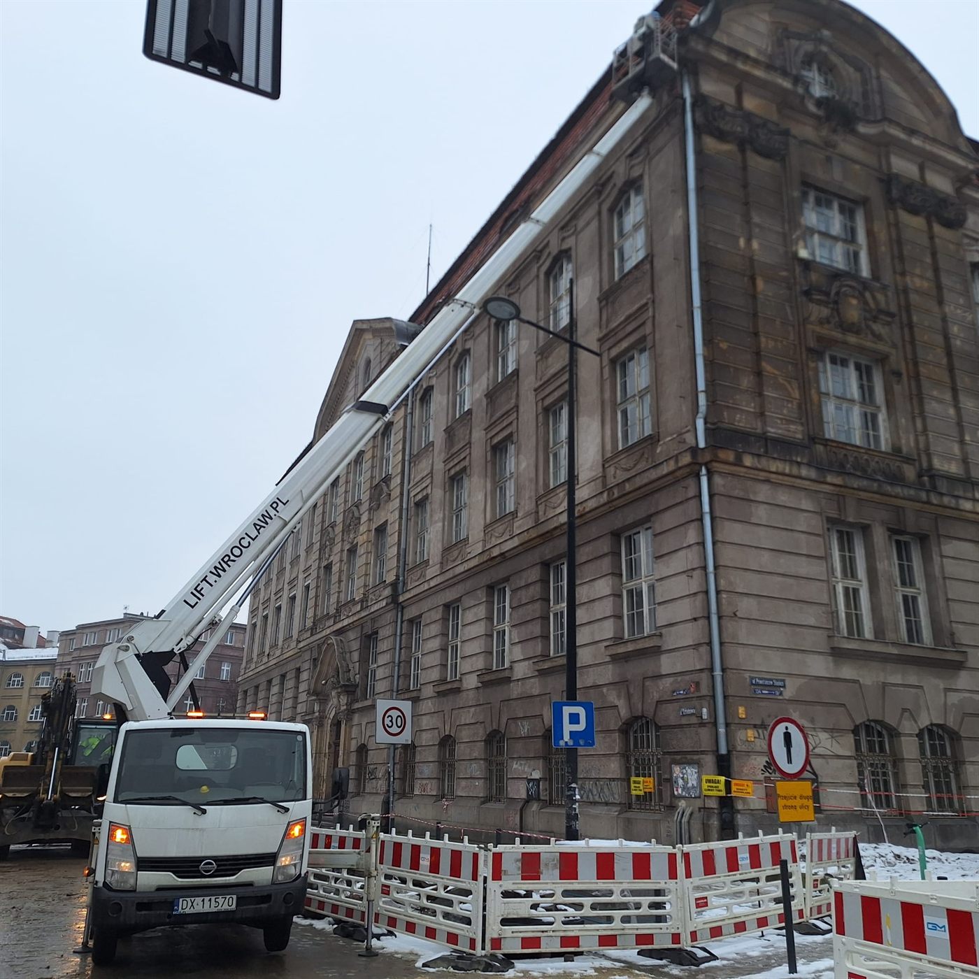 Operator w koszu podnośnika usuwa awarię na wysokości